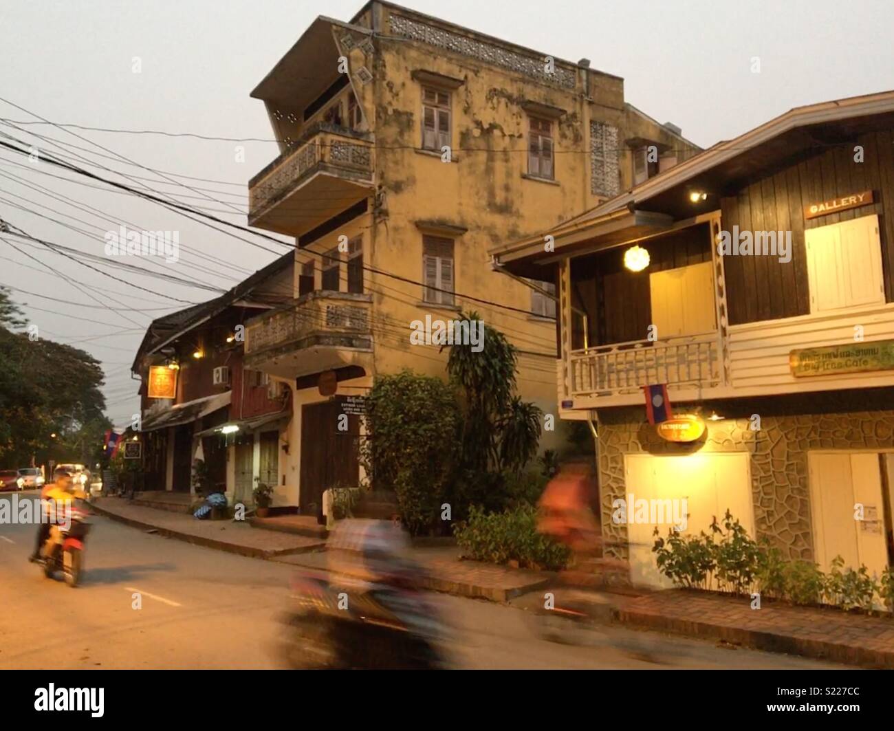 Scooter passato di equitazione di vecchi edifici in Luang Prabang Laos Foto Stock
