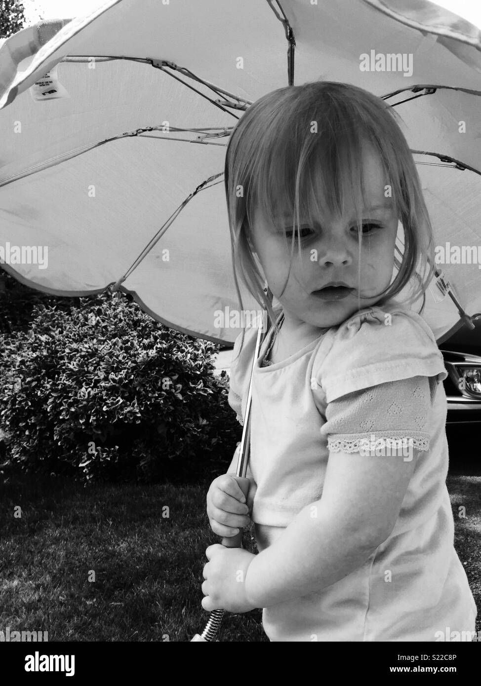 Bambina di tre anni con ombrellone Foto Stock