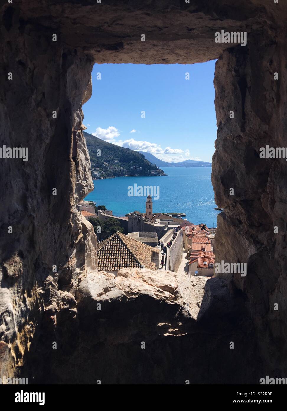Paese vecchio di Dubrovnik e l'adriatico attraverso una finestra nelle mura della città Foto Stock