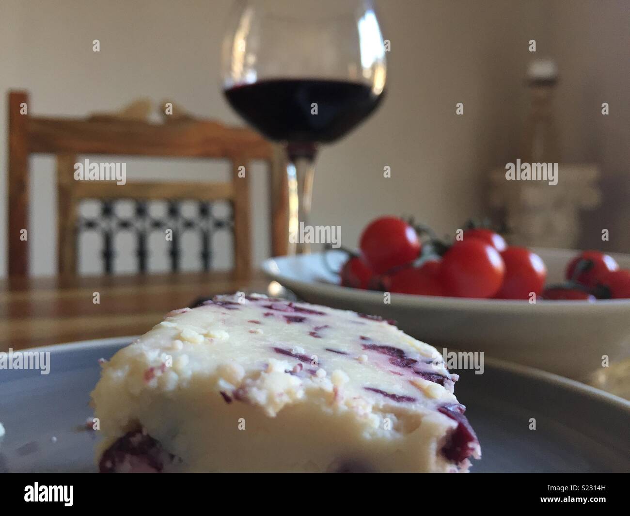 Formaggio con mirtilli rossi, rosso vino e stagionati pomodori ciliegia. Classica scena mediterranea. Foto Stock