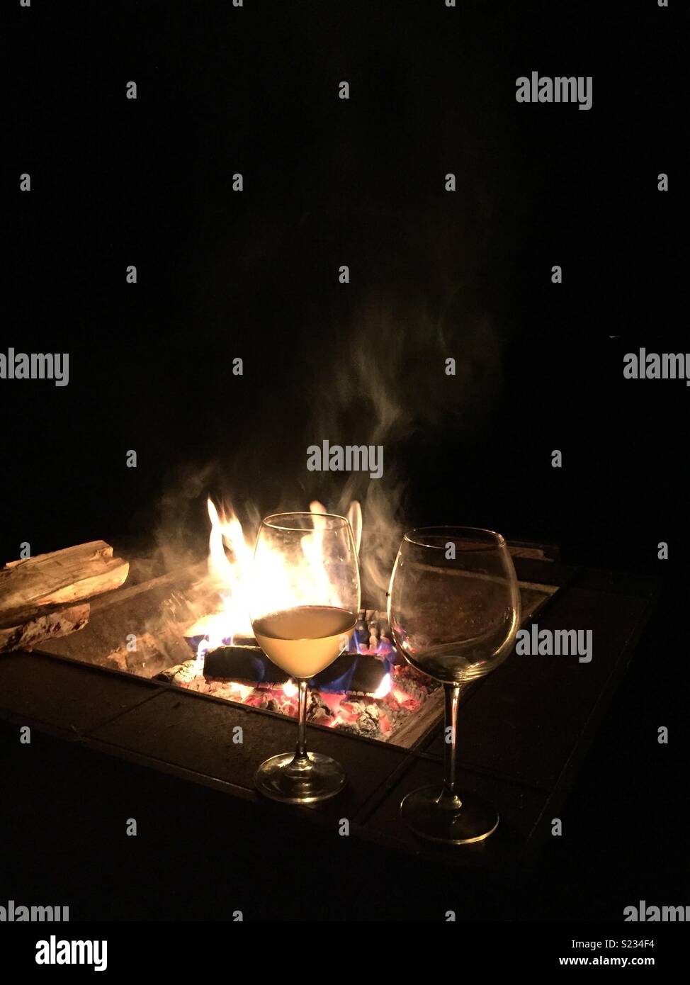 Una buca per il fuoco con bicchieri di vino Foto Stock