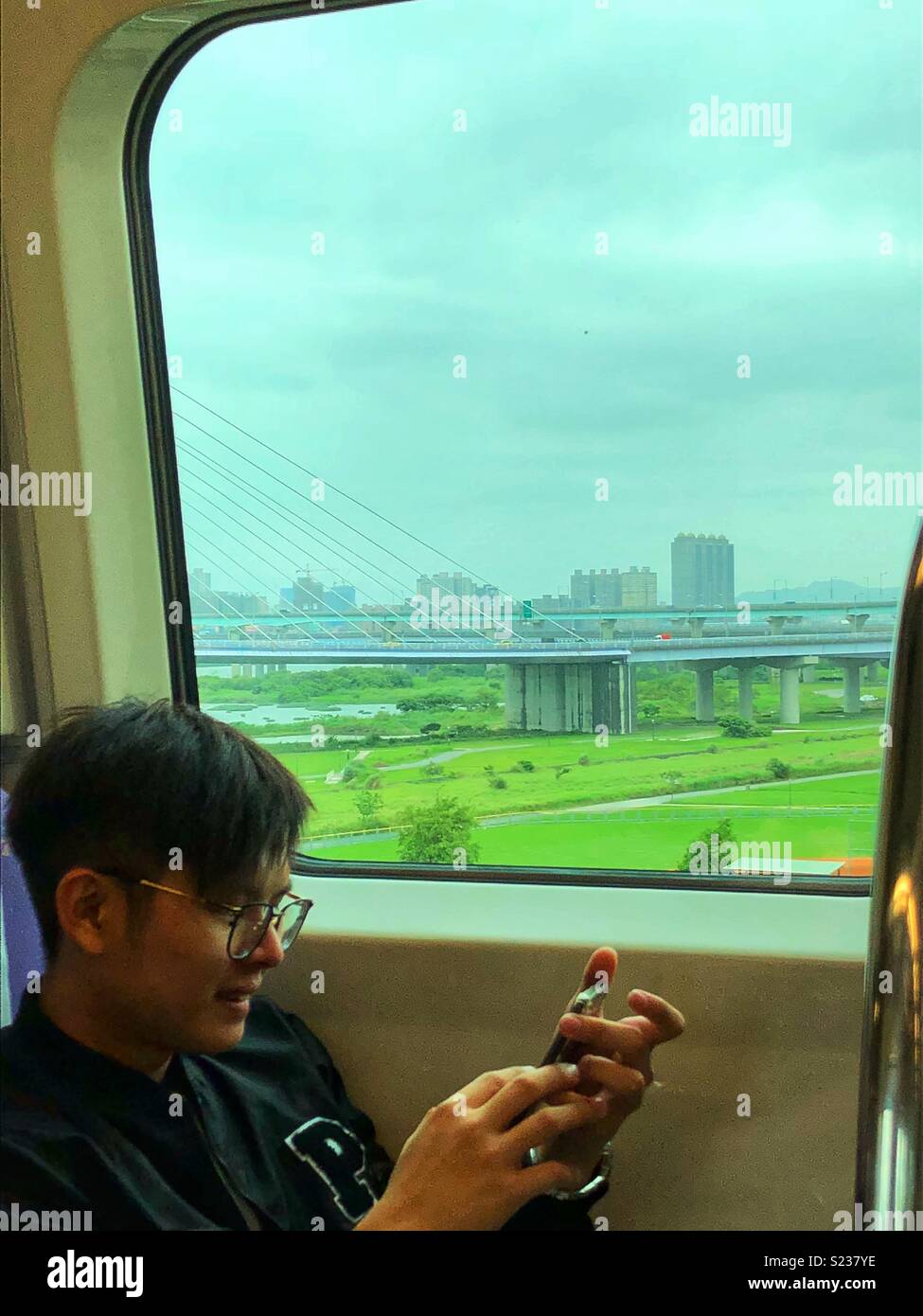 Treno passeggero utilizzando il suo smartphone. - Immagine stock catturata con smartphone