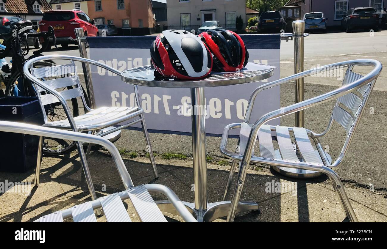 Caschi ciclismo su un street cafe tavolo in metallo Foto Stock