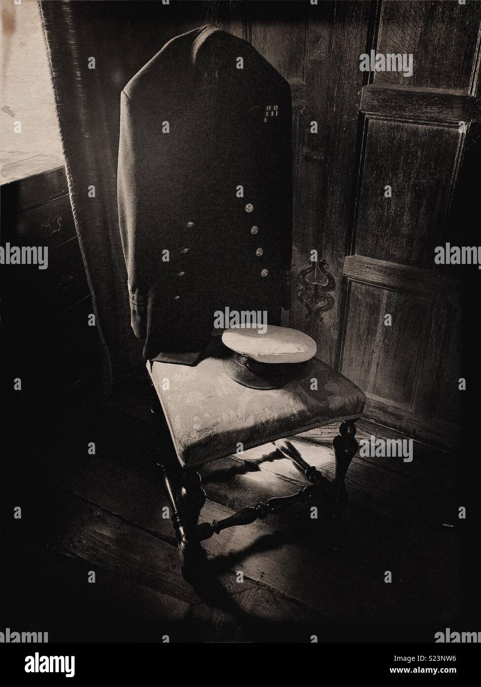 Old navy/addetto navale uniforme su una sedia vicino alla finestra in pannelli di quercia camera. - Immagine stock catturata con smartphone