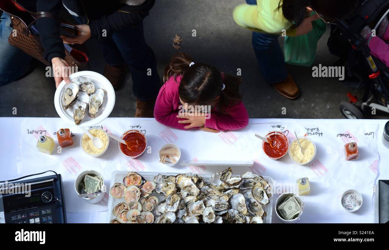 Vista dall'alto di una bambina in attesa presso un oyster bar Foto Stock