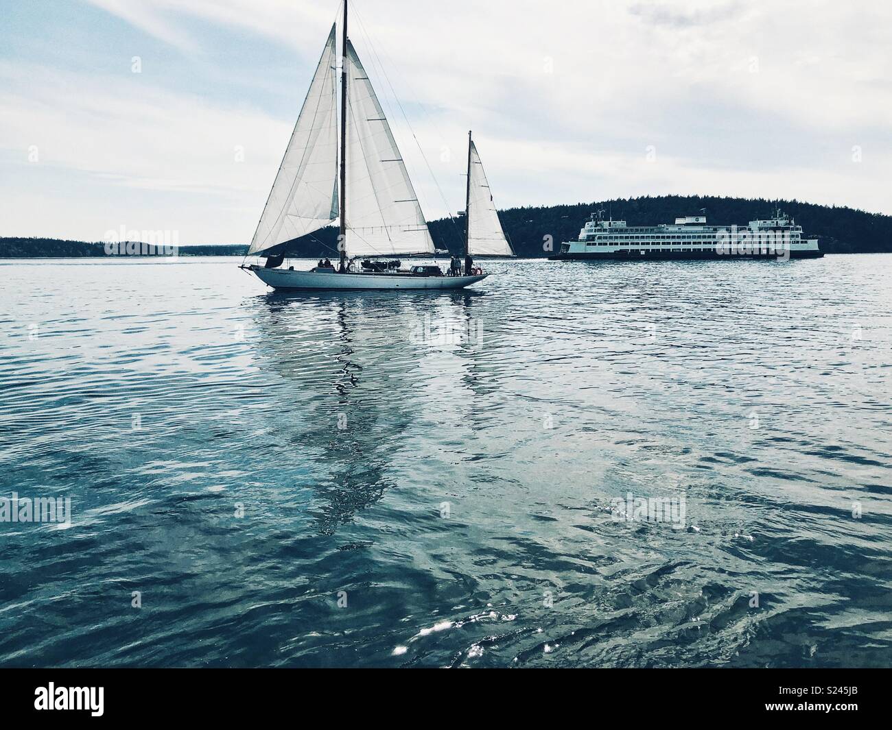 Classic Pacific Northwest scena - barca a vela e un traghetto su acqua in San Juan Islands Foto Stock