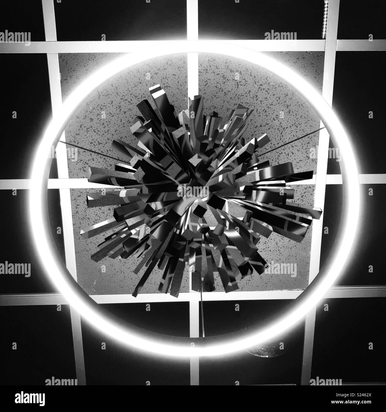 Un abstract artwork digitale dotato di un cerchio incandescente su una griglia con un materiale metallico, oggetto pungenti nel centro Foto Stock