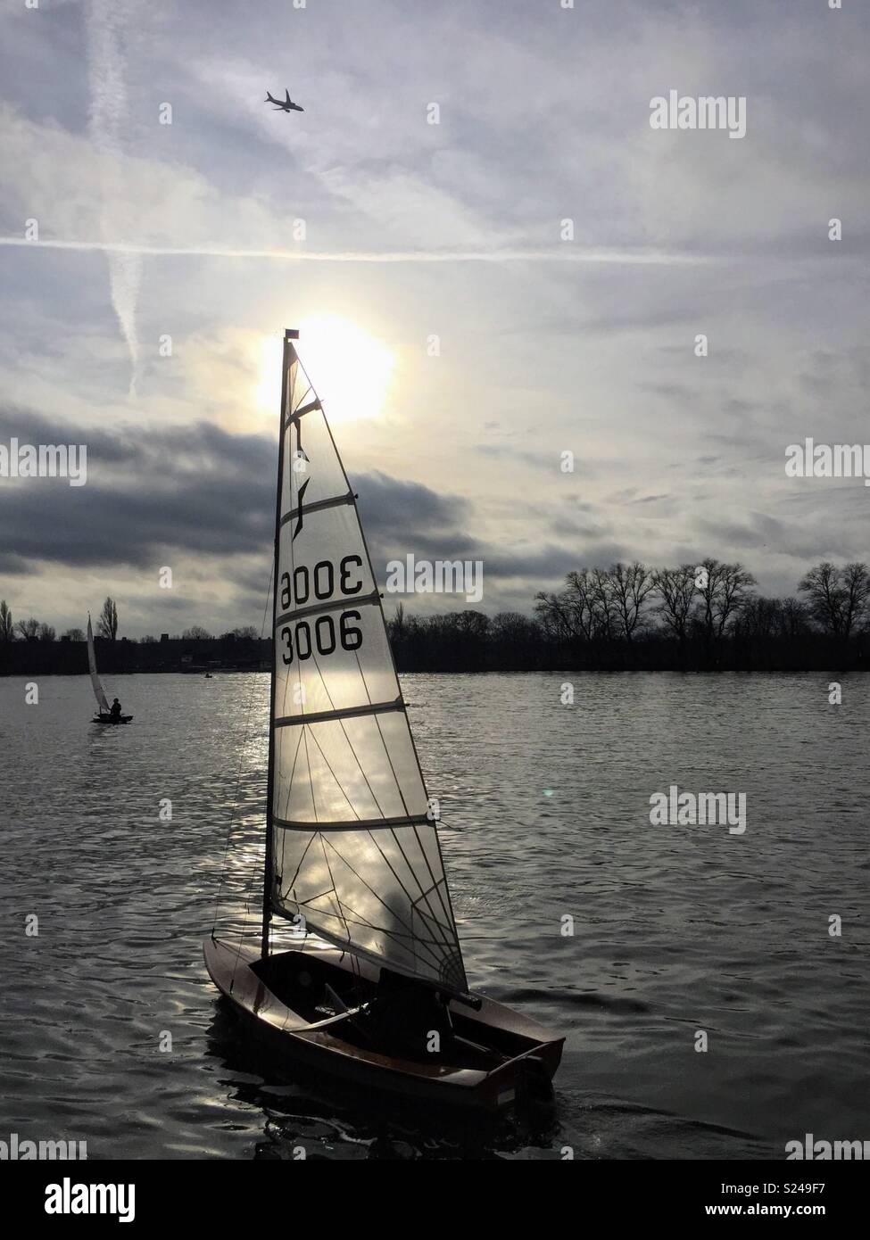 Barche a vela sul Fiume Tamigi, Londra, con il sole basso nel cielo. Foto Stock