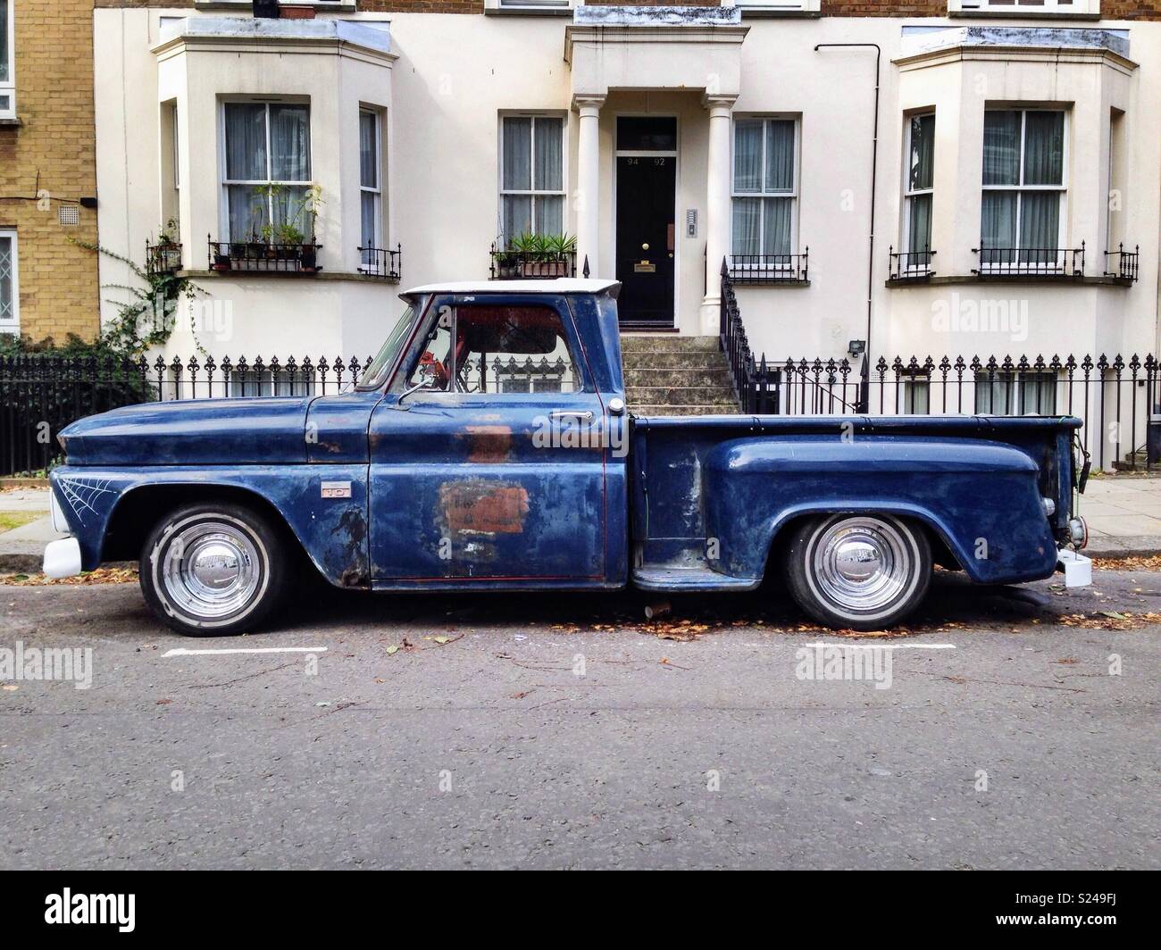 Vintage blue American pickup truck parcheggiato al di fuori di edificio in stucco di Notting Hill Gate. Foto Stock