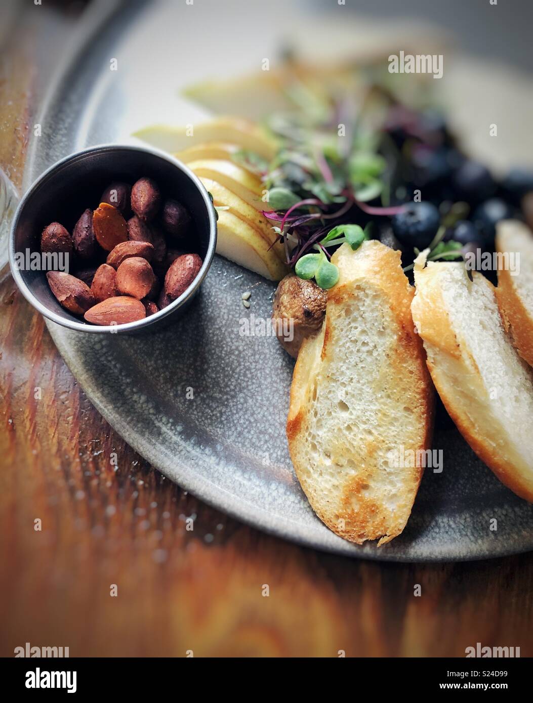 Antipasto di fantasia sulla piastra di metallo con mandorle tostate e toast Foto Stock