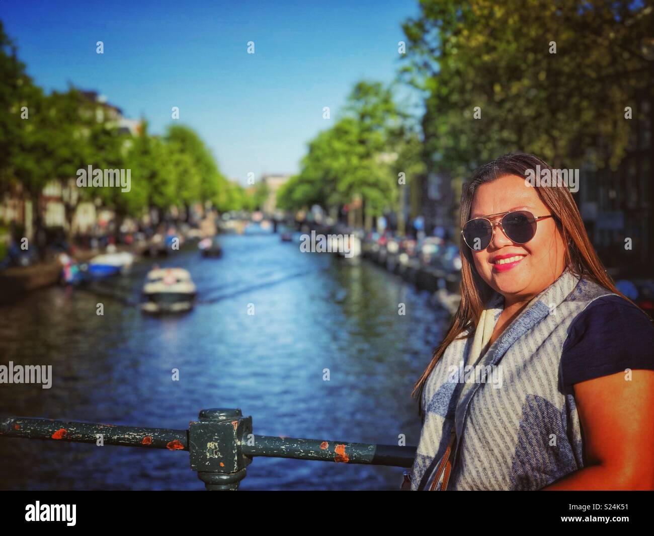 Una bella signora in posa per una foto accanto al canale di Amsterdam. Foto Stock