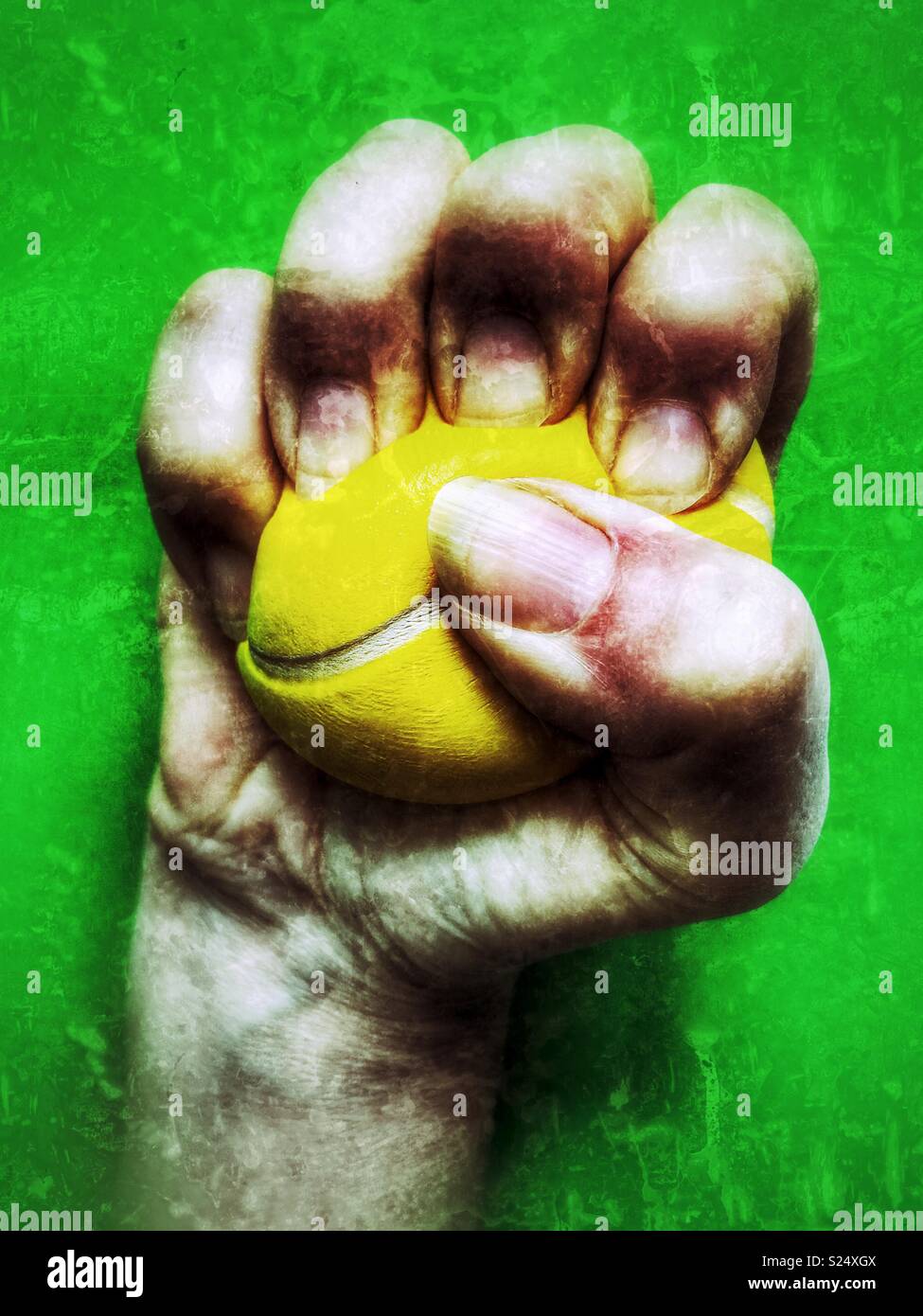 Per alleviare lo stress, palla, che vengono schiacciati in un pugno chiuso contro un semplice sfondo verde Foto Stock