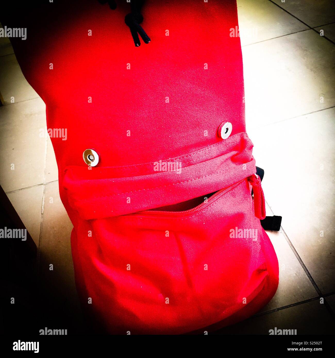 Volto amichevole su un sacchetto rosso - Immagine stock catturata con smartphone