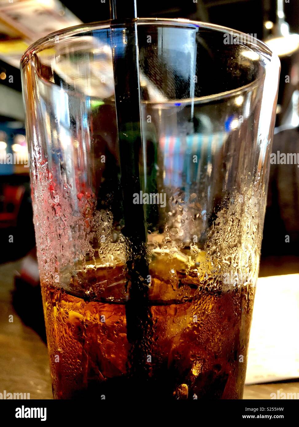Mezzo bicchiere pieno di iced cola Foto Stock