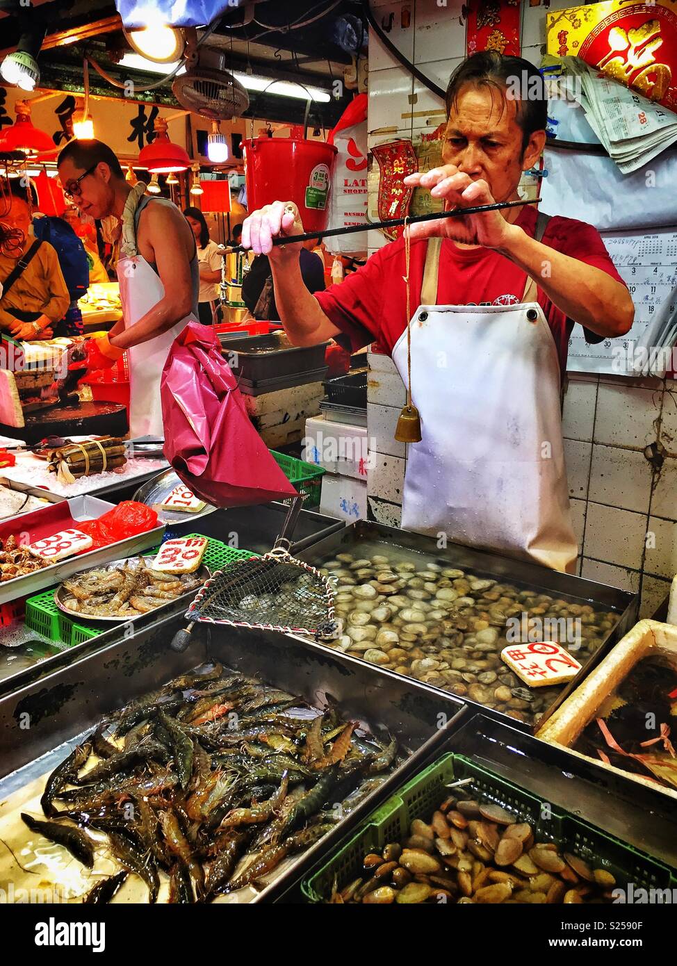 Un pescivendolo pesa produrre usando un cinese tradizionale steelyard  bilancia in un "mercato umido', Yuen Long, Nuovi Territori di Hong Kong  Foto stock - Alamy