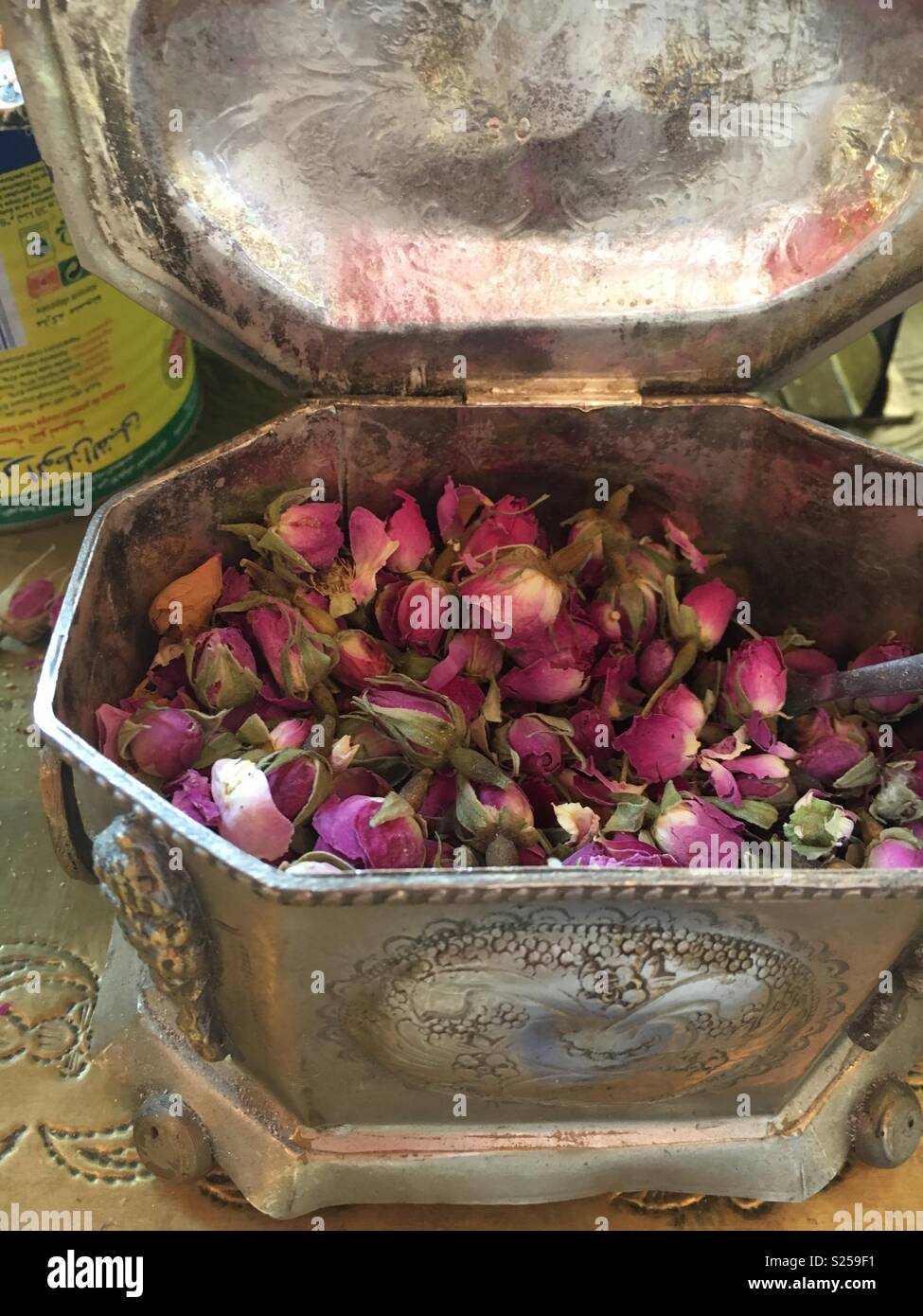 Un argento ciotola riempita con secchi petali di rosa Foto Stock