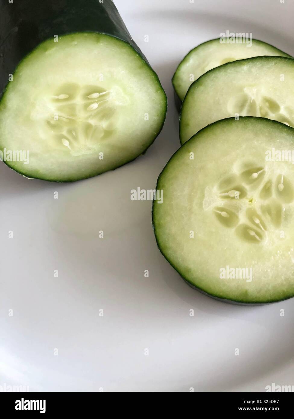 Fette di cetriolo su piastra bianca - Immagine stock catturata con smartphone