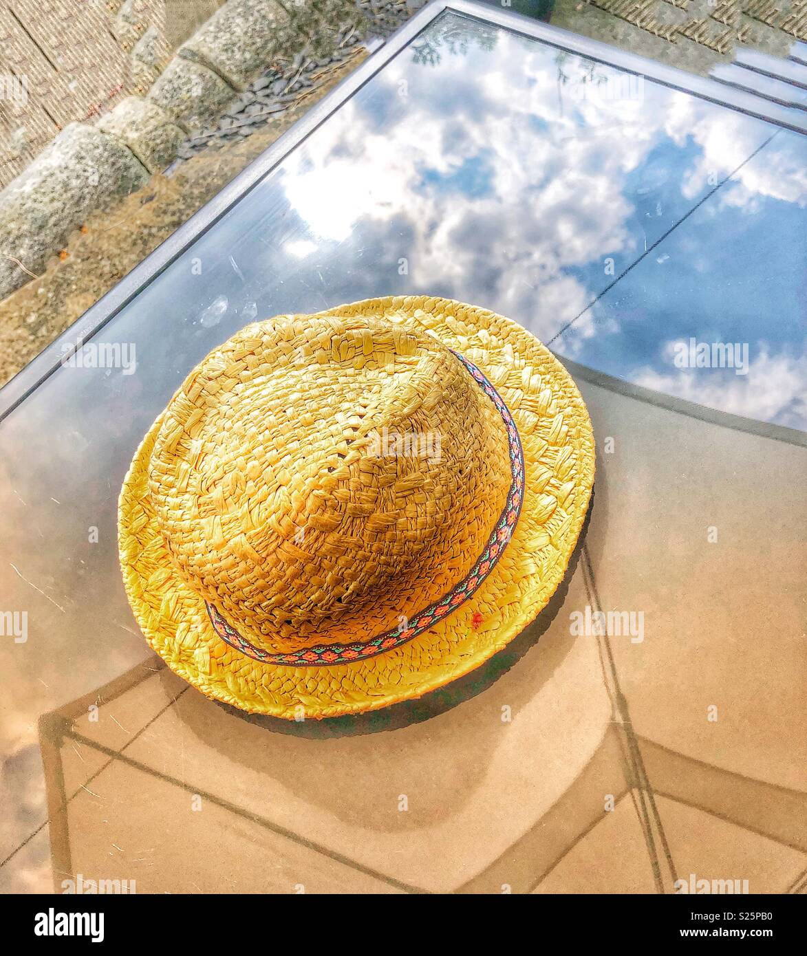 Hat in appoggio su un tavolo di vetro con sky riflessione Foto Stock