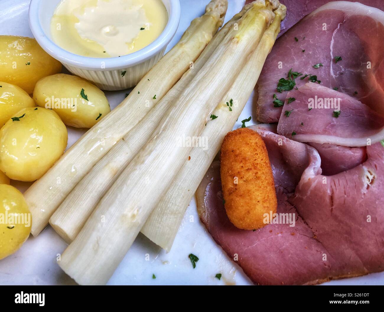 Un tipico pasto tedesco con asparagi bianchi, patate e prosciutto affumicato. - Immagine stock catturata con smartphone