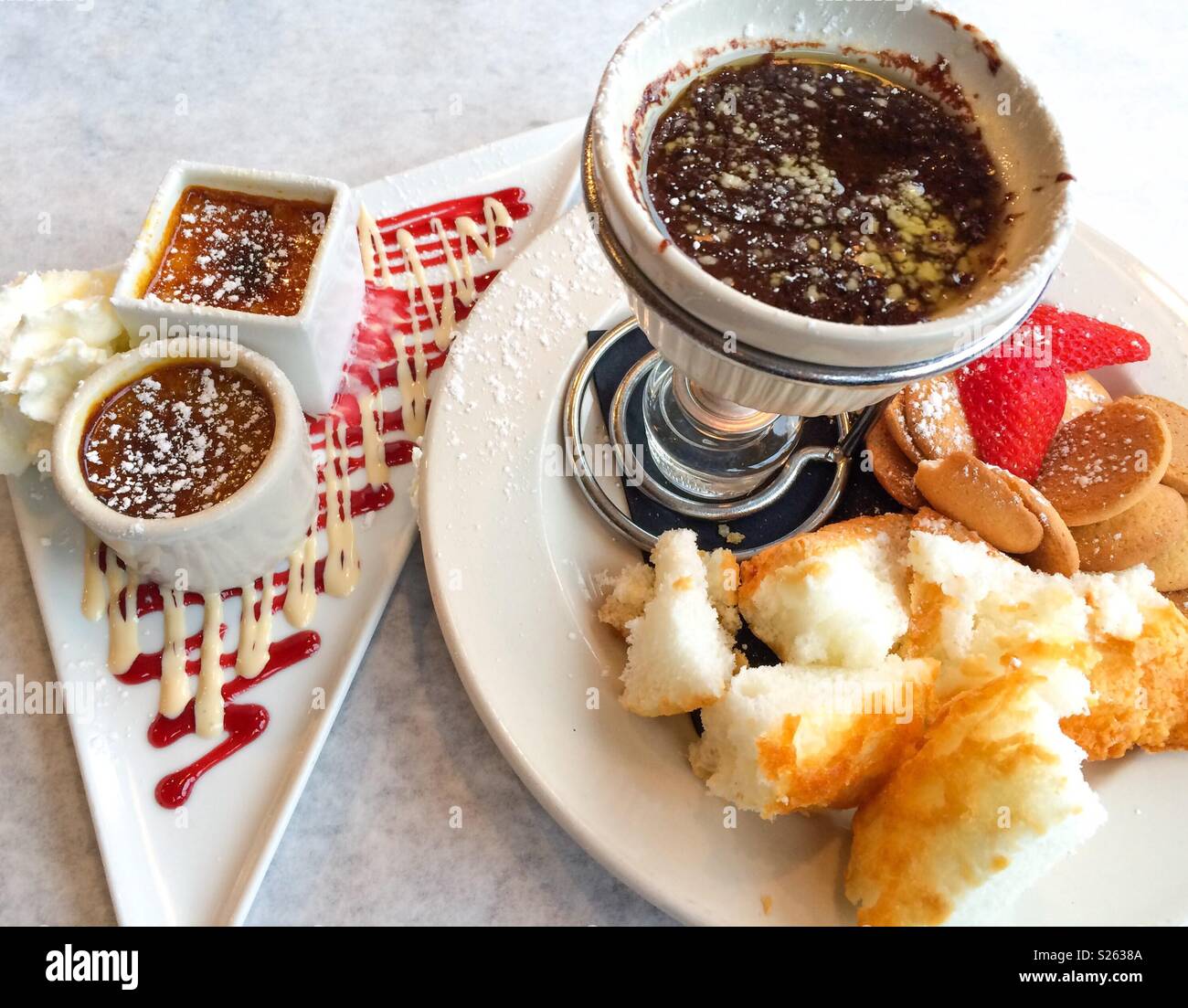 Il dessert di crème brûlée e Fonduta di cioccolato bianco con torta, vaniglia cookies e fragole Foto Stock