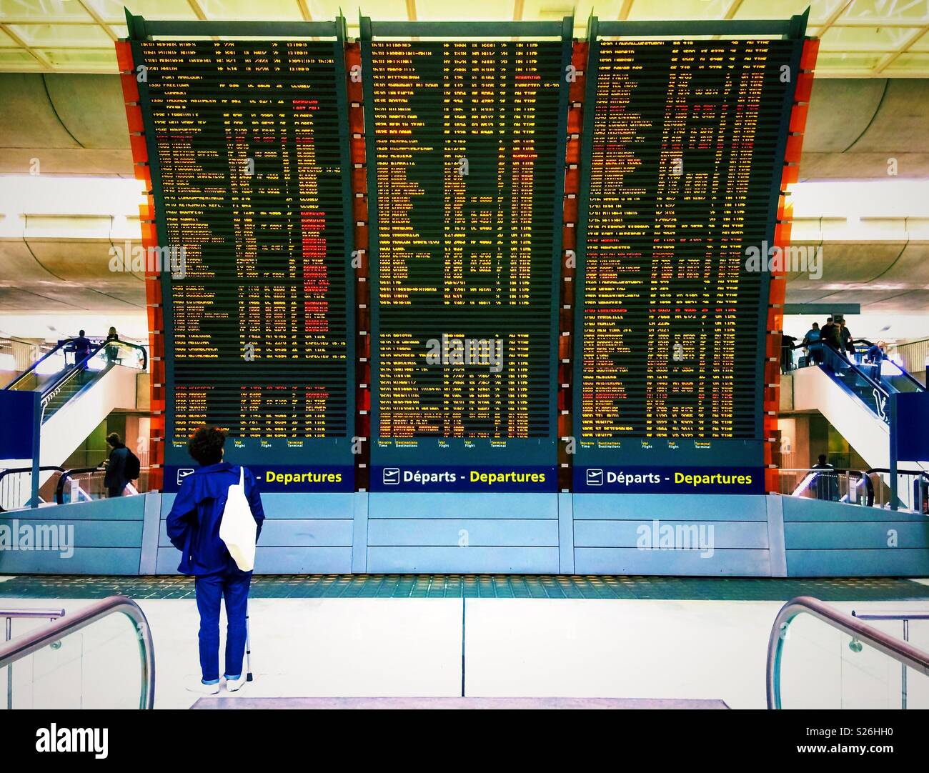 Il passeggero guardando lo schermo con informazioni voli di un sistema in un terminale dell'aeroporto Roissy CDG, Francia. Foto Stock