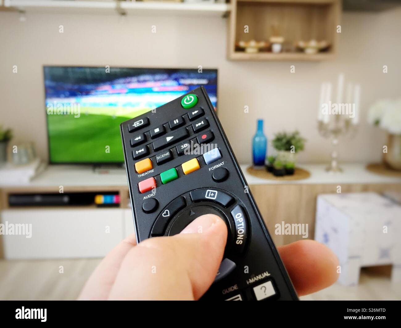Guardando i mondiali di calcio in televisione con telecomando - Immagine stock catturata con smartphone
