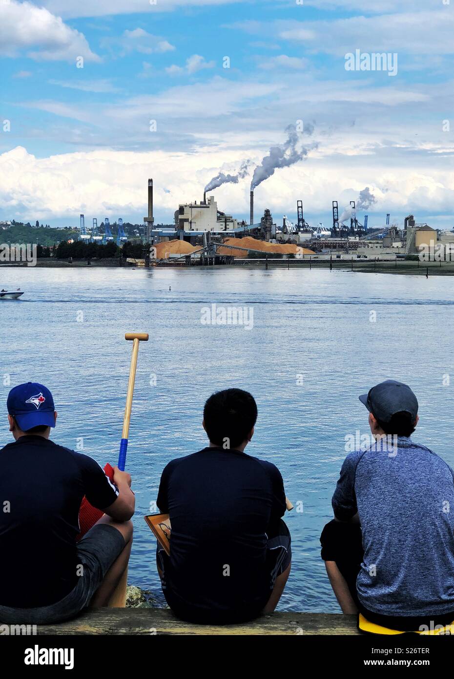 Tre uomo seduto e guardando alla zona industriale attraverso Thea Foss idrovia di Tacoma - Immagine stock catturata con smartphone