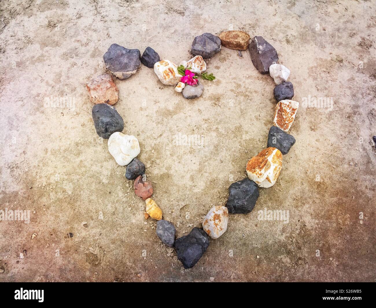 Progettazione di un cuore di pietra su una spiaggia. - Immagine stock catturata con smartphone