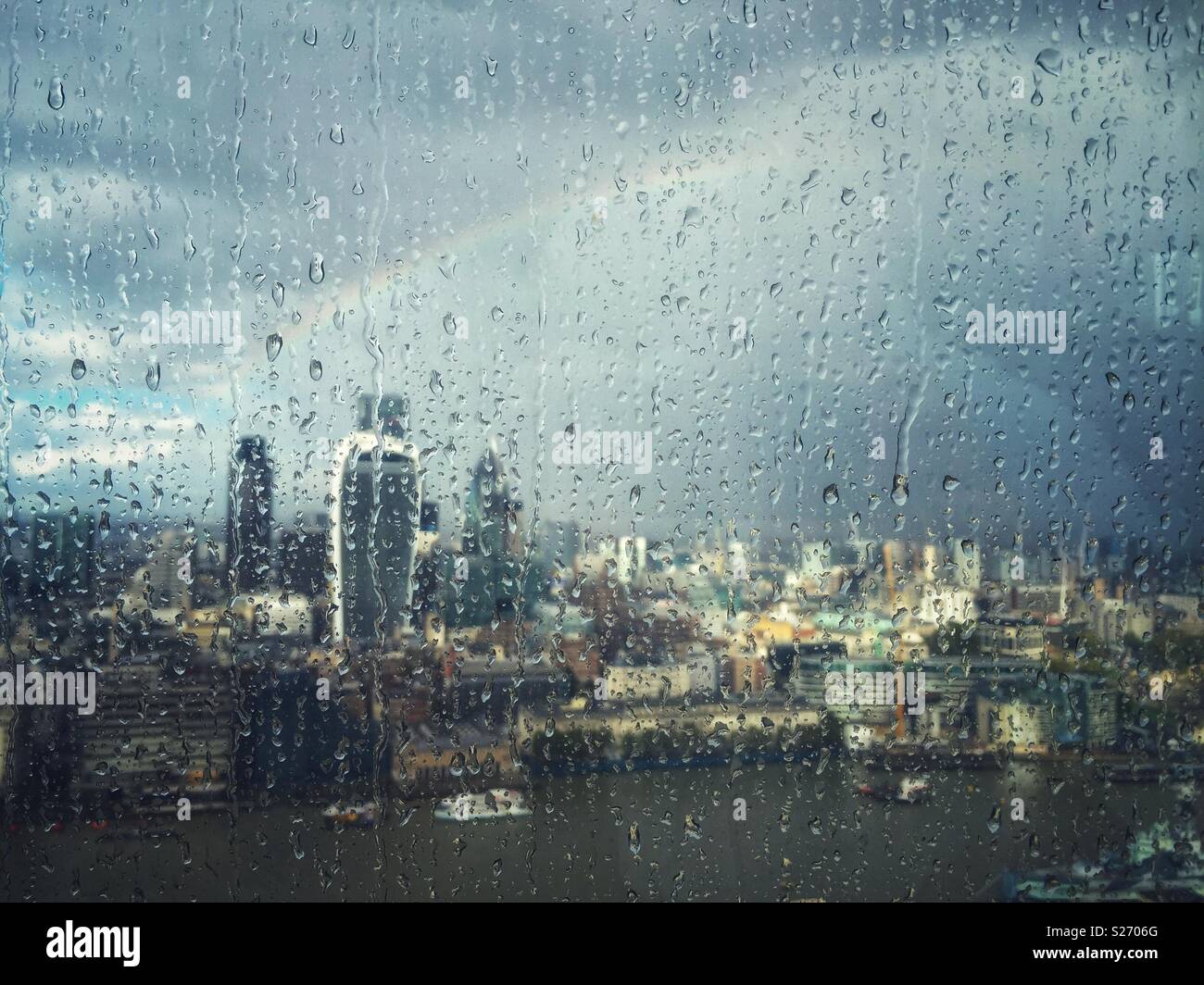 La pioggia sulla finestra del Shard, LONDRA, REGNO UNITO, guardando oltre il Tamigi verso Fenchurch Street e sulla città. Un arcobaleno illumina il cielo come il sole si rompe attraverso, illuminazione fino alla città di seguito. - Immagine stock catturata con smartphone