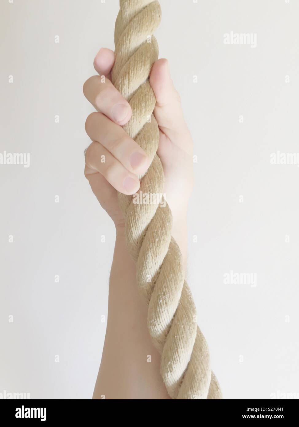 Un maschio della mano e del braccio di presa dello spessore di un pezzo di corda strettamente su sfondo bianco Foto Stock