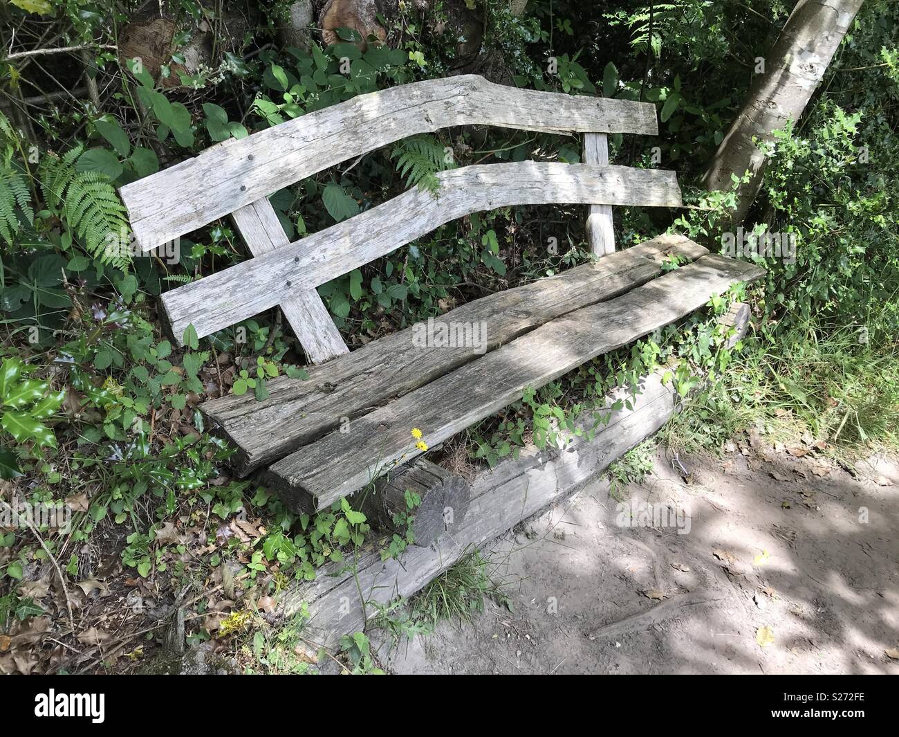 Vecchio ricoperta in legno rustico sedile unico Foto Stock
