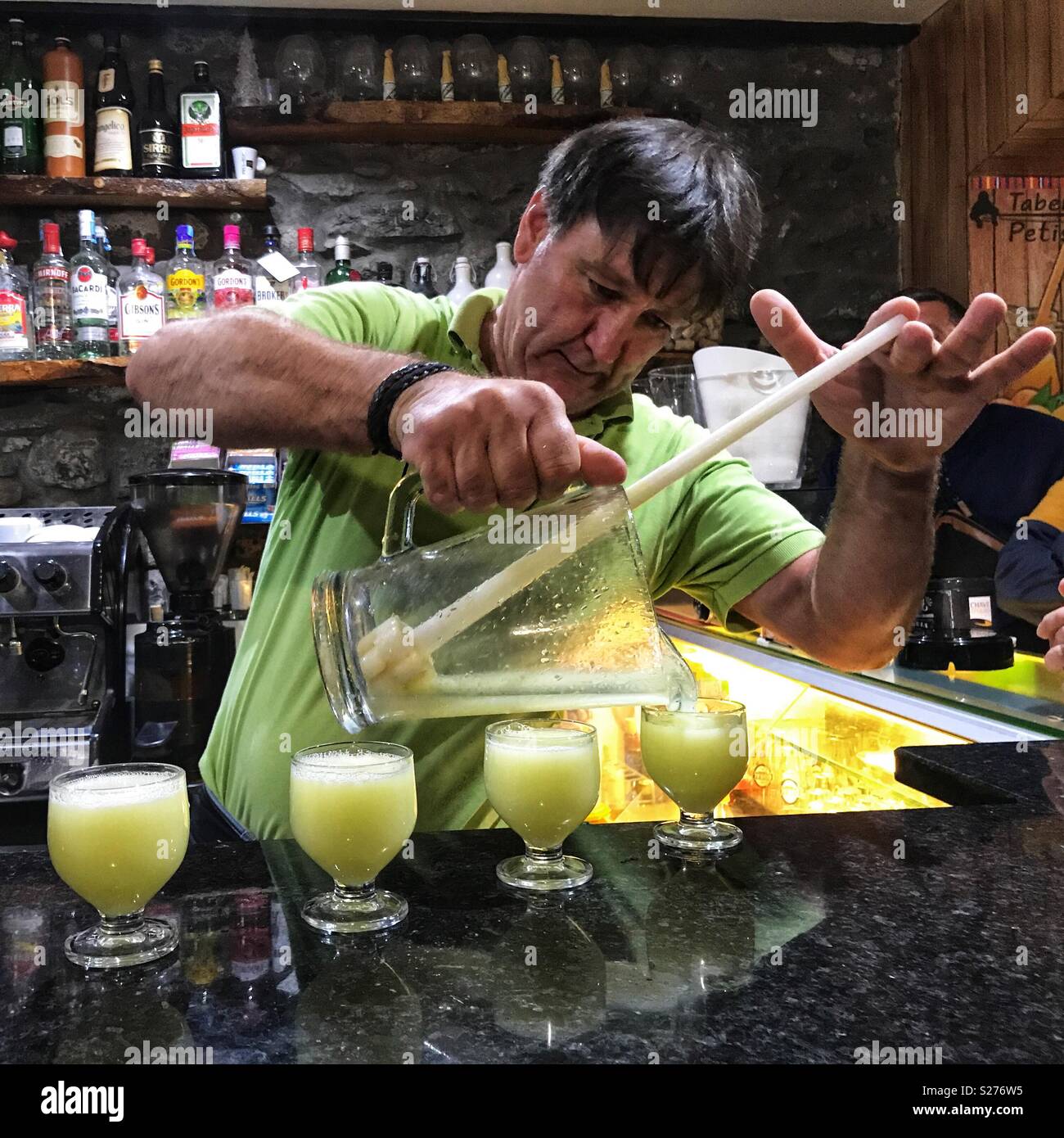 Bar uomo Poncha di miscelazione da Madeira, una tradizionale bevanda alcolica fatta con aguardente de cana, miele, zucchero e succo di limone. Madeira, Portogallo - Immagine stock catturata con smartphone