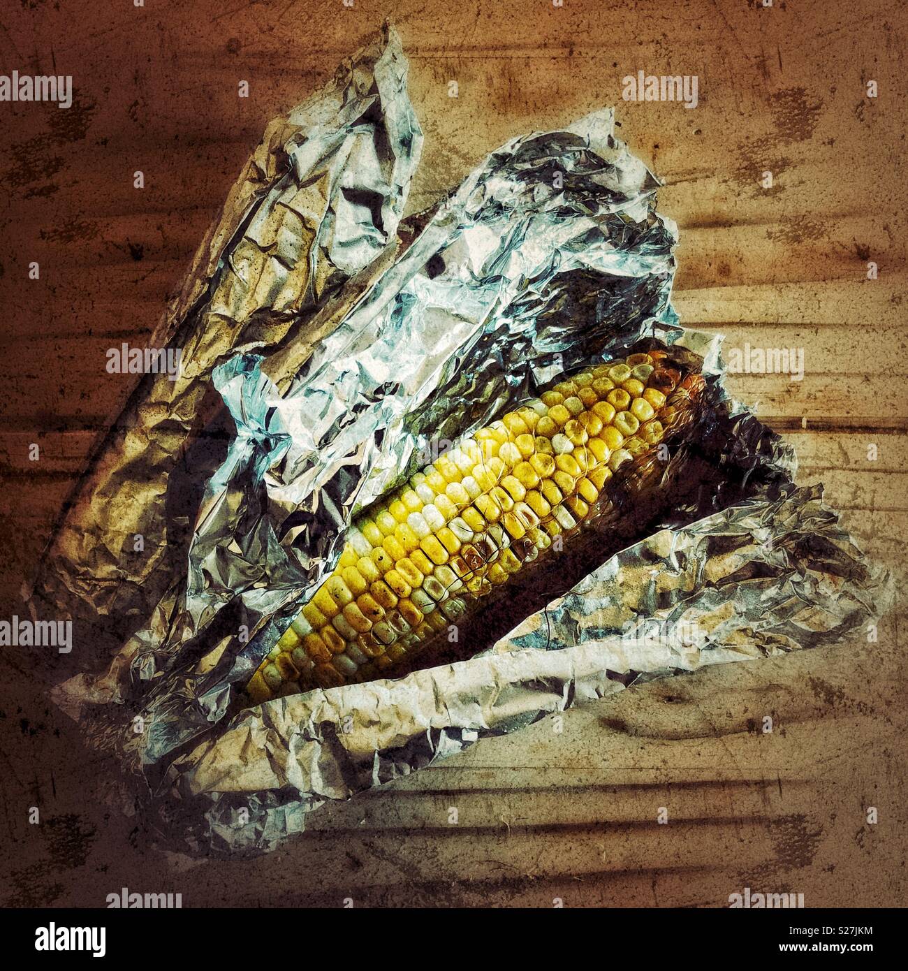 Barbeque sulla pannocchia di mais avvolti nel foglio di stagno con uno parzialmente scorporato Foto Stock