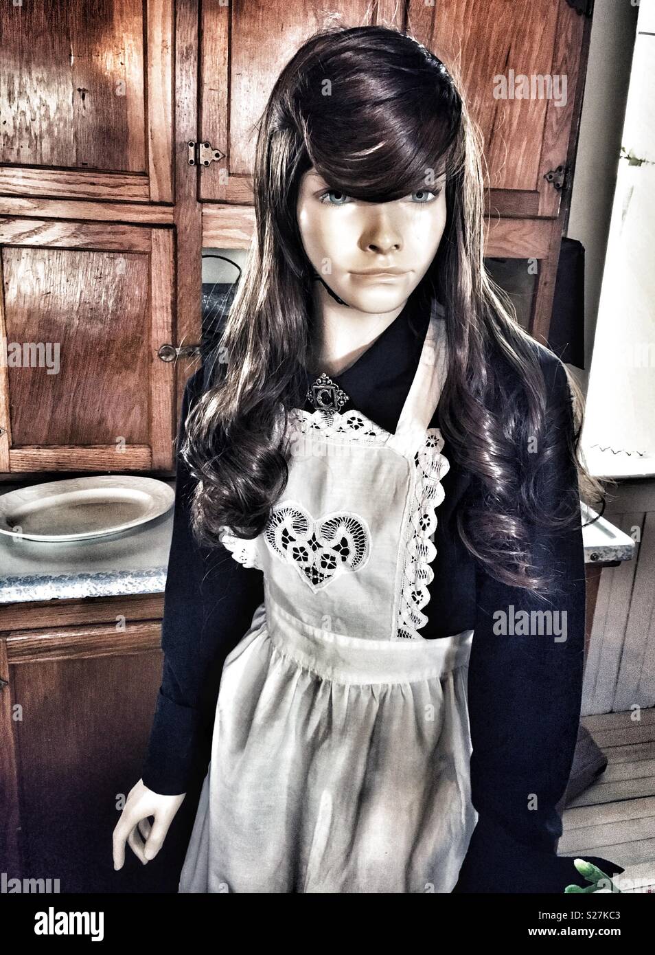 Manichino con capelli lunghi marrone in bianco Lacey cuore grembiule e abito nero - Immagine stock catturata con smartphone