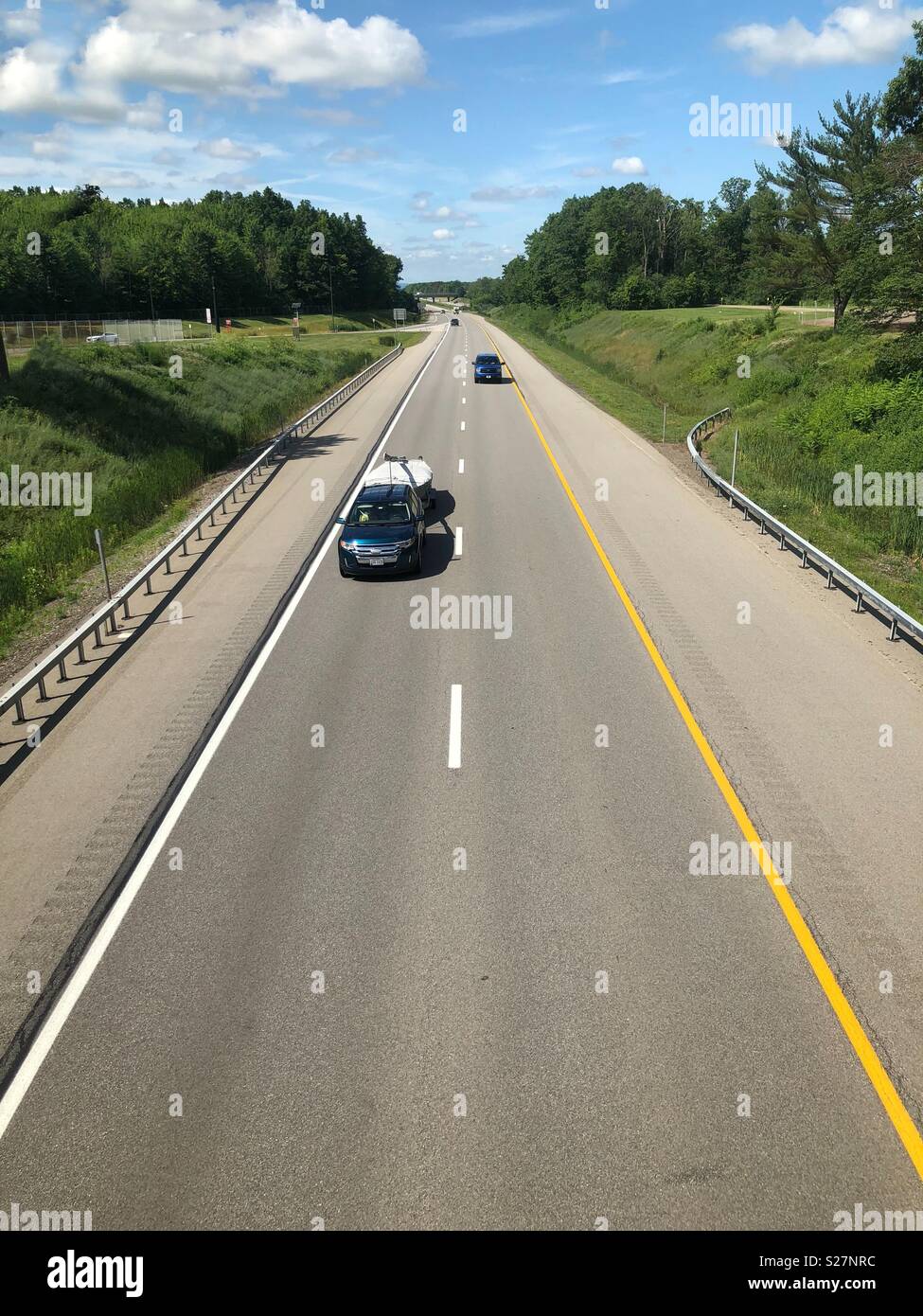 Una veduta aerea di una autostrada con camion e automobili guida su esso che allunga in distanza Foto Stock