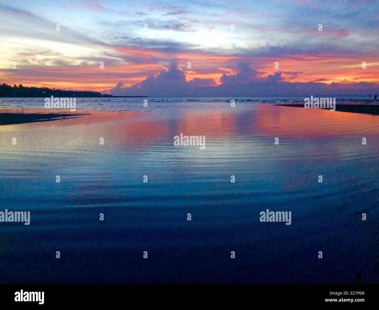 La sua schiacciante per vedere i colori dell'acqua e il cielo come il sole tramonta al di fuori dell'orizzonte. Foto Stock