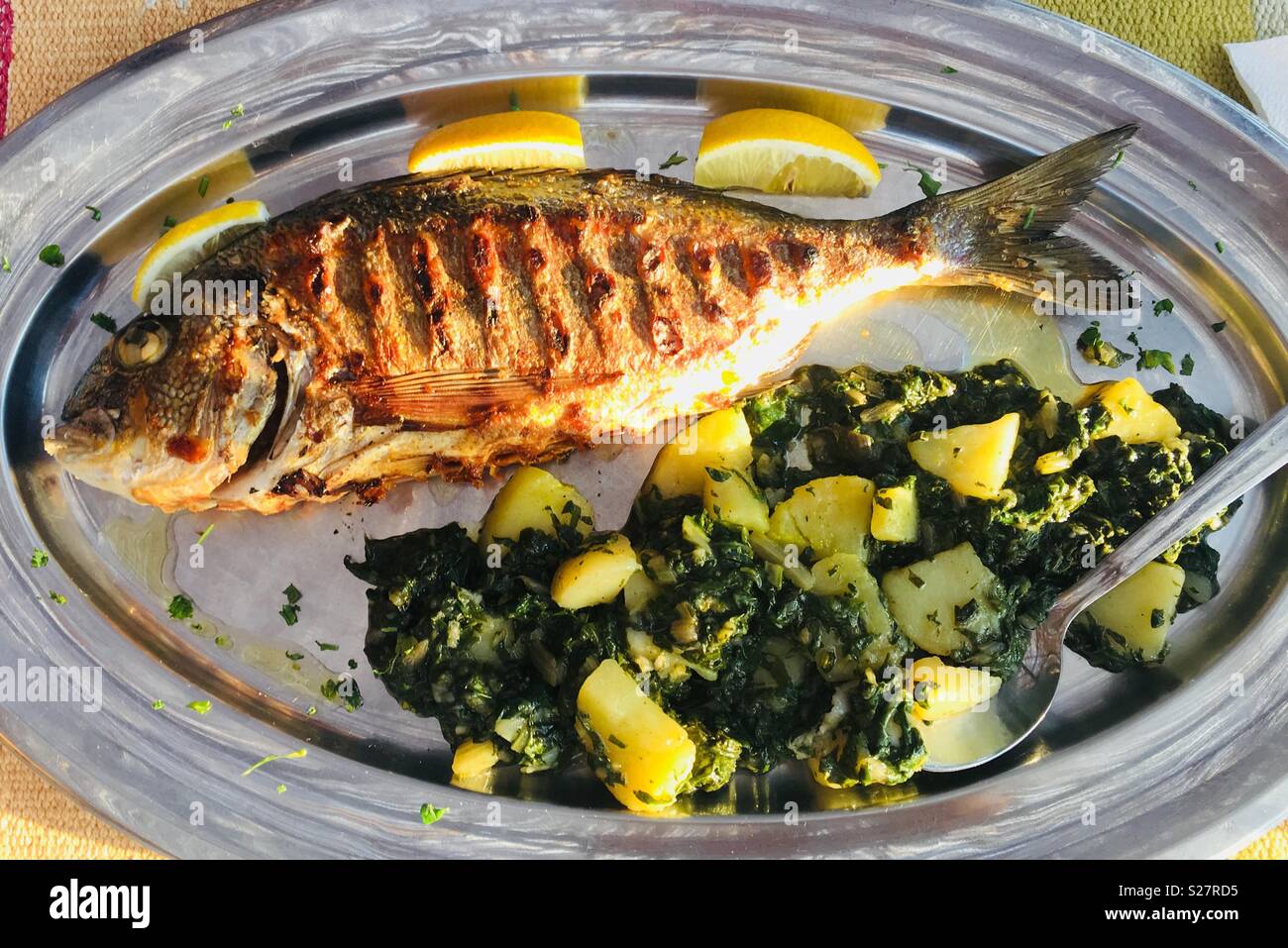 Grigliate di pesce dal Mare Adriatico servito con patate lesse e spinaci. Foto Stock