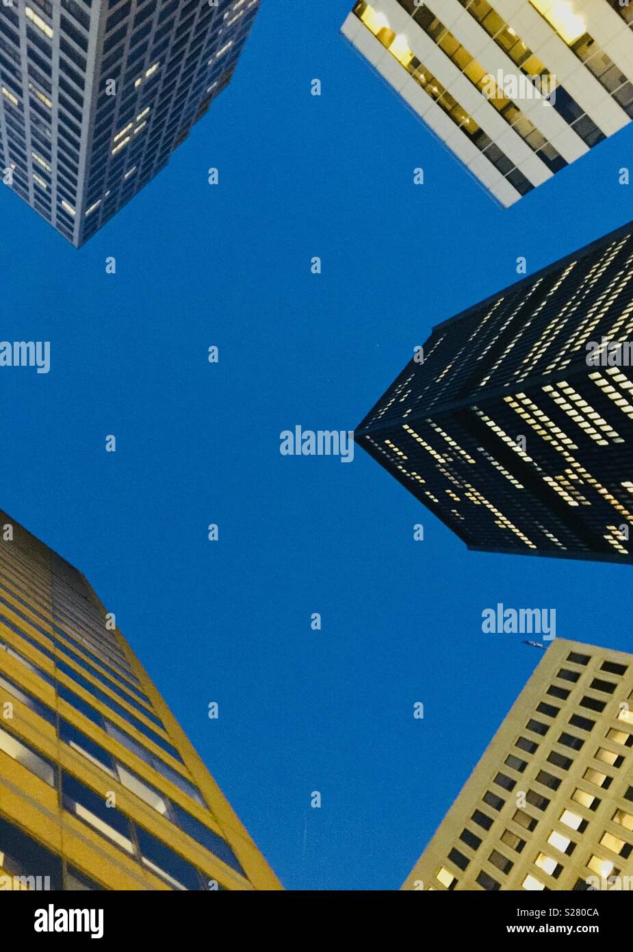 Cerca fino a edifici per uffici al crepuscolo con un cielo blu - Immagine stock catturata con smartphone