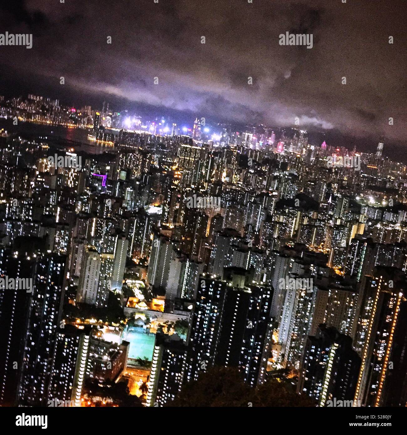 Le luci luminose dell'Isola di Hong Kong e Tsim Sha Tsui visto in tutta l'alta densità del paesaggio urbano della Penisola di Kowloon dal vecchio Sha Tin Pass Road, Hong Kong (neutro) Foto Stock