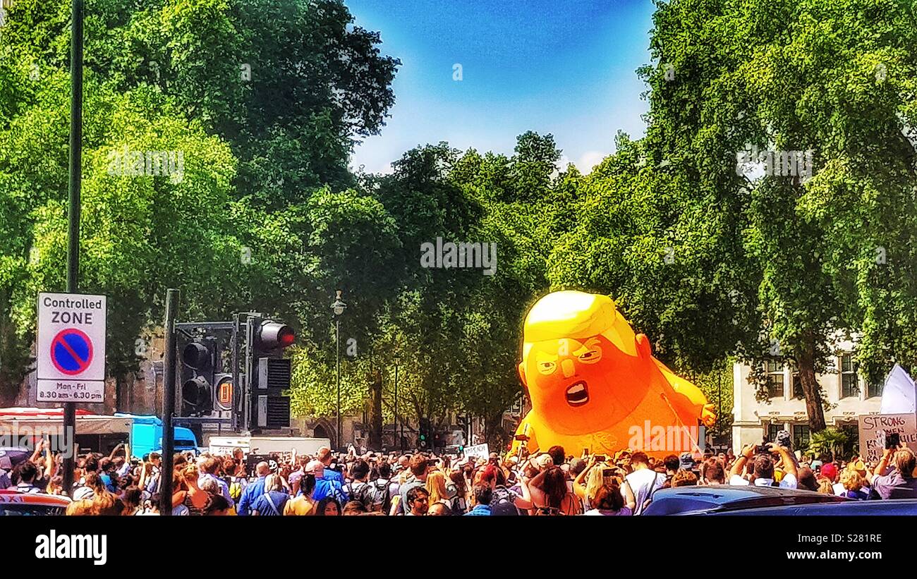 Donald Trump Baby Blimp circondato da una folla di manifestanti durante Donald Trump's UK visita la Piazza del Parlamento, Londra - Immagine stock catturata con smartphone
