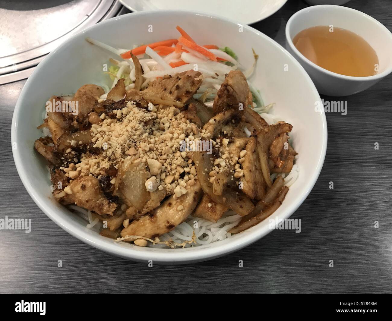 Vietnamita di pollo alla citronella Noodle piatto con una piccola ciotola di salsa di pesce sul lato Foto Stock