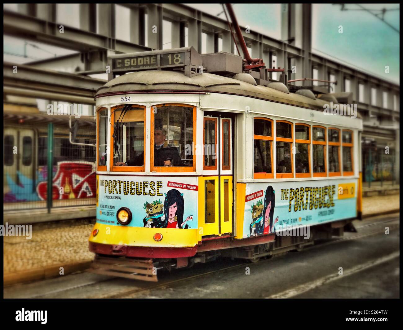 Una fermata del tram che corre sul percorso 18 nel centro di Lisbona, Portogallo. Elettrico di questo sistema di trasporto pubblico è stata introdotta nel 1901. La maggior parte delle vetture del tram sono decorate con inserzioni. Credito foto - © COLIN HOSKINS. Foto Stock
