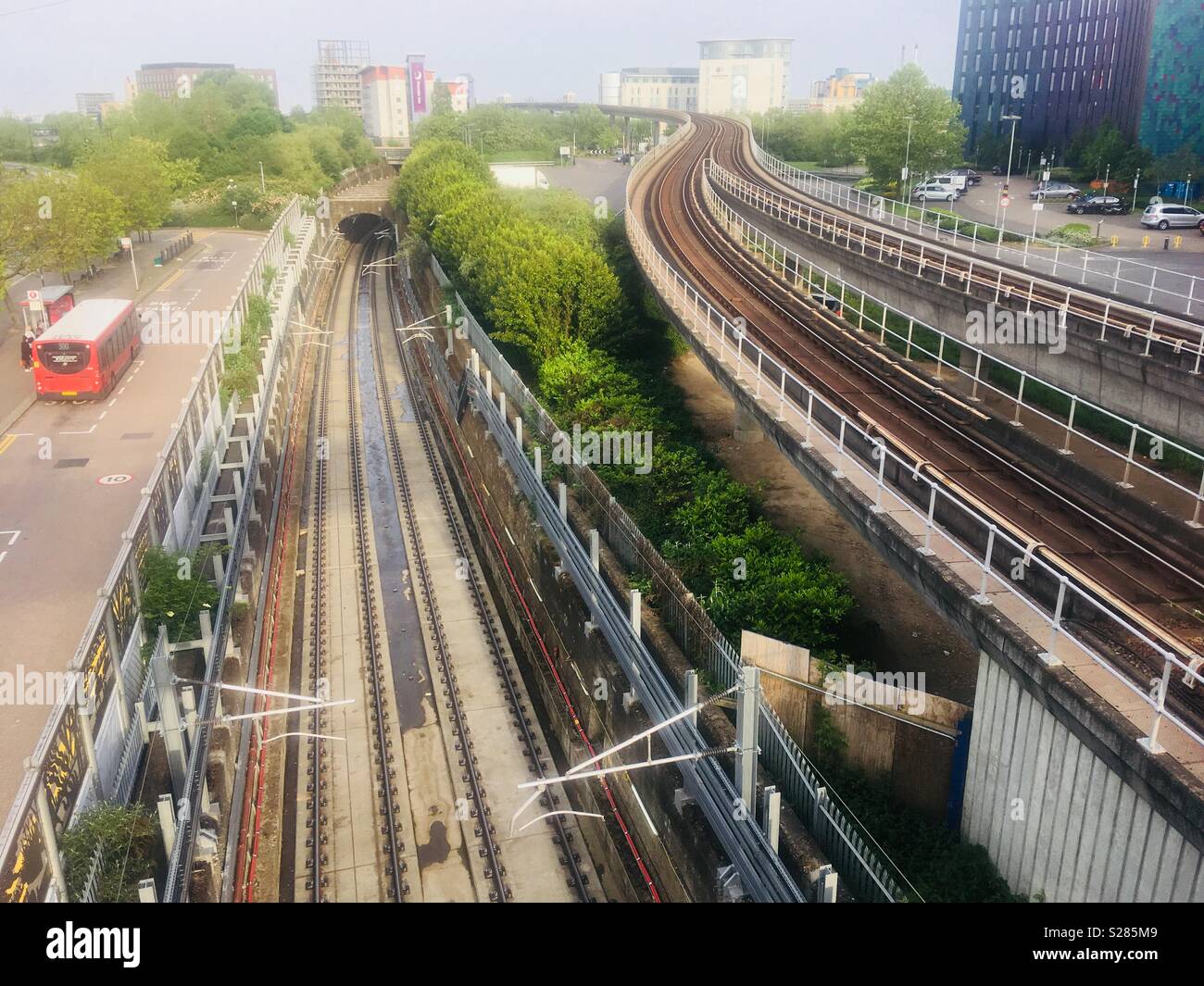 Vista est da Prince Regent Station sulla linea delle Docklands Light Railway, Londra, in primavera. Mostra la corrente pista rialzata, il nuovo Crossrail le vie e l'ingresso in galleria. Foto Stock