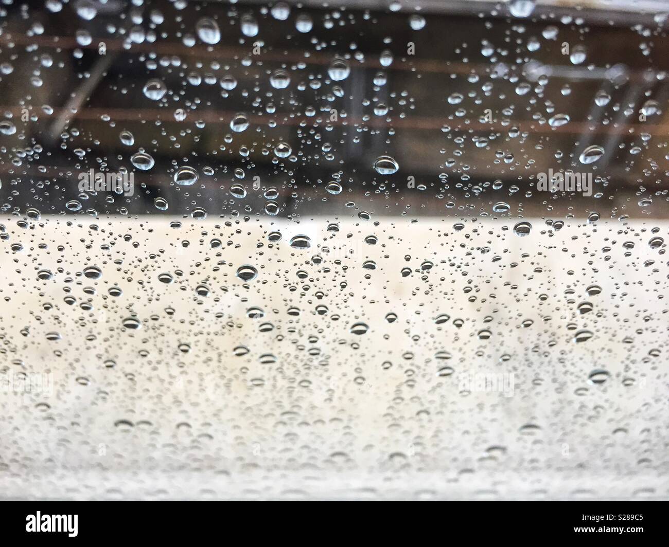 Gocce di pioggia su un vetro di un finestrino. Concetto di stagione - Immagine stock catturata con smartphone