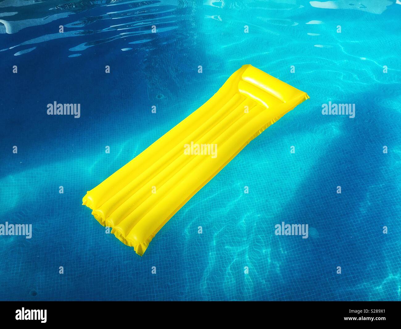 Giallo lilo in blu piscina Foto Stock