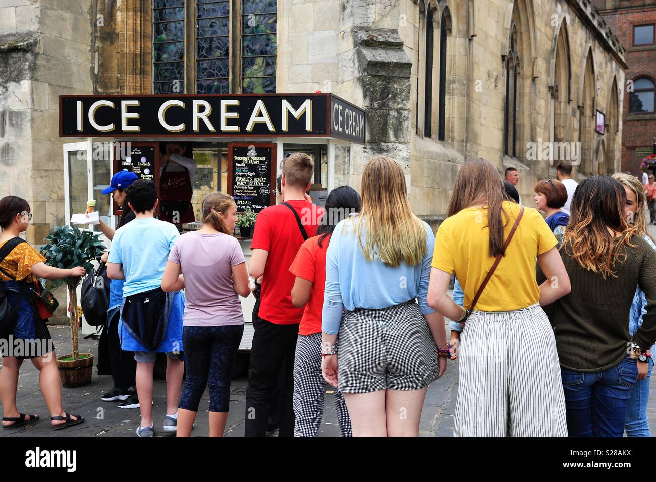 Una lunga fila di persone in piedi in un gelato stallo in una torrida giornata calda durante una ondata di caldo in York, Regno Unito - Immagine stock catturata con smartphone