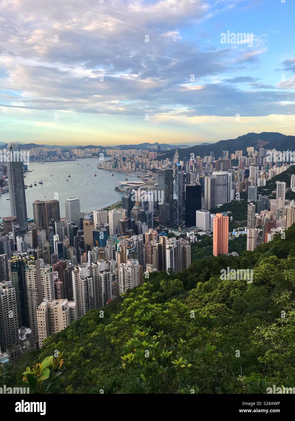 Una vista verso il basso su Hong Kong Central District e il porto di Victoria Peak al tramonto. Foto Stock