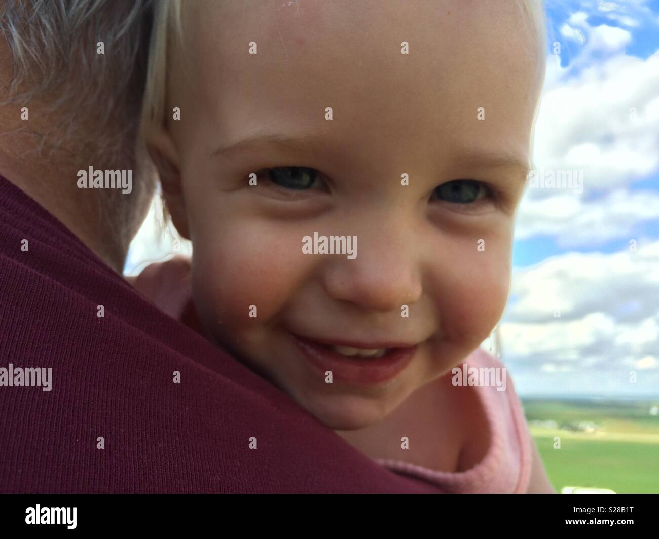 Sorridente baby essendo trattenuto dal nonno Foto Stock