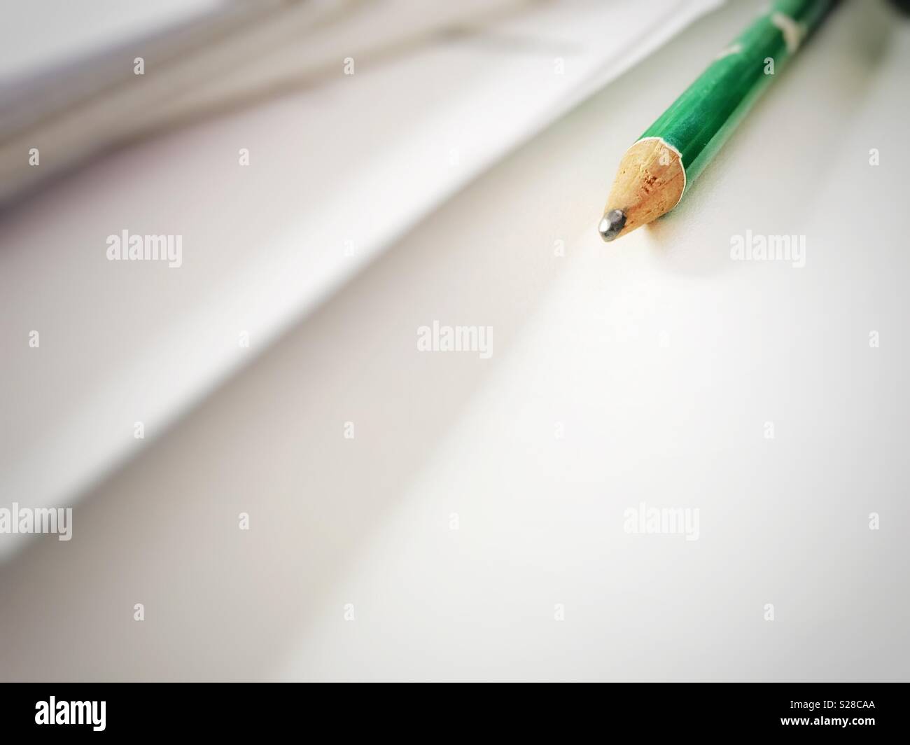 Matita verde su una scrivania bianca. Copia dello spazio. Creatività e minimalismo concept - Immagine stock catturata con smartphone