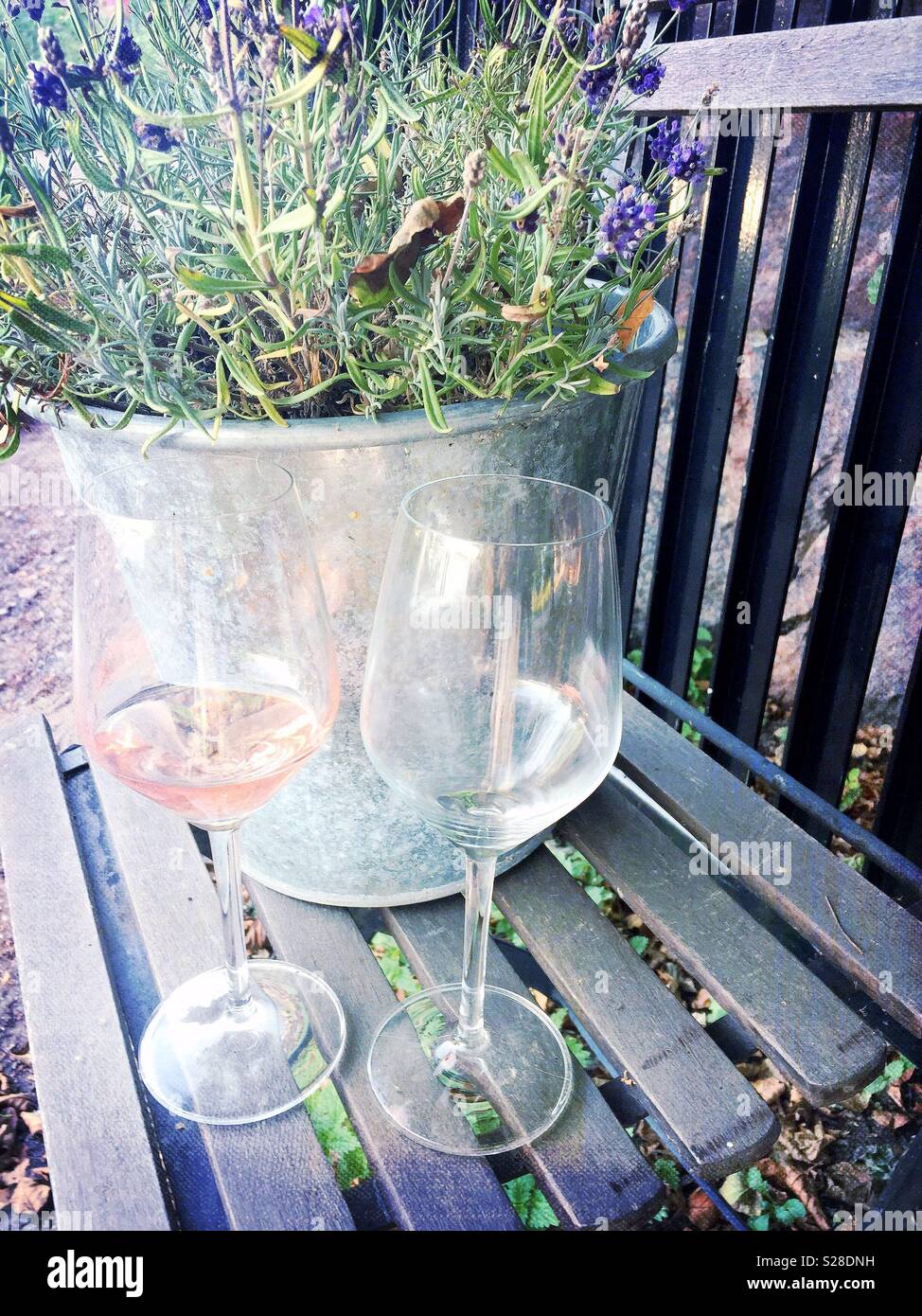 Due bicchieri di vino su una sedia in legno con fiori di colore blu Foto Stock